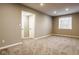 Spacious basement with a window, carpeted floor, and a door, providing an open area ready for customization at 14910 Briarpatch Cir, Carmel, IN 46033