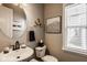 Neutral powder room featuring a pedestal sink, framed art and window at 14910 Briarpatch Cir, Carmel, IN 46033