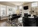 Cozy living room with a fireplace, textured wall, and ample natural light from large windows at 14910 Briarpatch Cir, Carmel, IN 46033