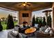 Inviting covered patio with a brick fireplace, comfortable seating, and serene backyard views at 14910 Briarpatch Cir, Carmel, IN 46033