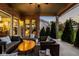 Stylish covered patio with brick pillars, comfortable wicker seating, and well manicured landscape at 14910 Briarpatch Cir, Carmel, IN 46033