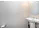Half bath features a pedestal sink, round mirror, and a toilet paper holder at 15391 Mystic Rock Dr, Carmel, IN 46033