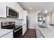 Modern kitchen features stainless steel appliances, granite countertops, and white cabinetry at 15391 Mystic Rock Dr, Carmel, IN 46033