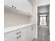 Functional mudroom with built-in cabinets and counter space, leading to a carpeted bedroom with a backyard view at 15391 Mystic Rock Dr, Carmel, IN 46033