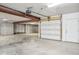 Spacious garage featuring concrete walls and floors, metal beam support, and an automatic garage door at 1557 N College Ave # 3, Indianapolis, IN 46202