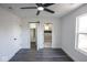 A well lit bedroom features modern ceiling fan, grey floors, and white walls with access to bathroom and closet at 1711 Ringgold Ave, Indianapolis, IN 46203