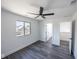 A well lit bedroom features modern ceiling fan, grey floors, and white walls with a street view at 1711 Ringgold Ave, Indianapolis, IN 46203
