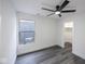 A well lit bedroom features modern ceiling fan, grey floors, and white walls with a street view at 1711 Ringgold Ave, Indianapolis, IN 46203