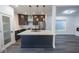 Open concept kitchen showcasing an island, stainless appliances, dark cabinetry, and wood floors at 1711 Ringgold Ave, Indianapolis, IN 46203