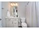 A classic bathroom with a clean white vanity, mirrored wall cabinet, and shower curtain, combining functionality and style at 17346 Haxby Ln, Westfield, IN 46074