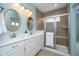 The stylish bathroom features a double vanity, granite countertops, and a glass-enclosed shower with neutral toned tiles at 17346 Haxby Ln, Westfield, IN 46074