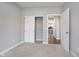 A bedroom with sliding closet doors and an open doorway revealing the kitchen, creating a modern, open feel at 17346 Haxby Ln, Westfield, IN 46074