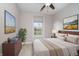 The cozy bedroom features bright artwork, a pond view, and a ceiling fan, blending comfort with scenic beauty at 17346 Haxby Ln, Westfield, IN 46074