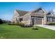 Charming home featuring a two-car garage, well-manicured lawn and tasteful landscaping under a clear sky at 17346 Haxby Ln, Westfield, IN 46074