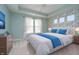 A stunning bedroom features tray ceilings, blue accents, and bright windows, creating a serene and inviting space at 17346 Haxby Ln, Westfield, IN 46074