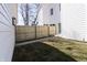 A fenced backyard between two houses has grass and a concrete walkway at 2053 Columbia Ave, Indianapolis, IN 46202