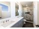 Bathroom featuring double sink vanity, modern fixtures and glass shower with marble walls and black tile flooring at 2053 Columbia Ave, Indianapolis, IN 46202