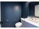 Stylish powder room features gray vanity with marble countertop, toilet and mirror at 2053 Columbia Ave, Indianapolis, IN 46202