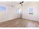 Spacious bedroom with wood-look floors, three windows, ceiling fan and white trim at 2053 Columbia Ave, Indianapolis, IN 46202
