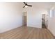 Spacious bedroom with light wood flooring, ceiling fan, white trim, and walk in bath and closet at 2053 Columbia Ave, Indianapolis, IN 46202