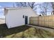 A white garage with a blue door and a wooden fence next to a concrete walkway at 2053 Columbia Ave, Indianapolis, IN 46202