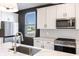 Bright kitchen features stainless steel appliances, white cabinets and island with quartz countertops at 2053 Columbia Ave, Indianapolis, IN 46202