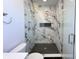 Modern glass shower featuring marble walls, black herringbone tile floor, and overhead shower fixture at 2053 Columbia Ave, Indianapolis, IN 46202