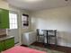 A dining area complemented by a round table with stools, a small freezer, and natural window light at 212 Walnut St, Greenfield, IN 46140