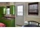 A cozy kitchen featuring bright green cabinetry and a sink area with a window for natural light at 212 Walnut St, Greenfield, IN 46140
