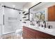 Modern bathroom featuring a double vanity, sleek black fixtures, and a glass-enclosed shower at 24 Thornhurst Dr, Carmel, IN 46032