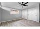Neutral bedroom featuring laminate wood floors, large window with blind and double closets with sliding doors at 24 Thornhurst Dr, Carmel, IN 46032