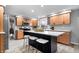 Updated kitchen featuring wooden cabinets, stainless steel appliances, and a large center island with barstool seating at 24 Thornhurst Dr, Carmel, IN 46032