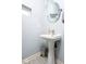 Cozy half bathroom with a pedestal sink and a modern round mirror at 2421 Grand Fir Dr, Greenwood, IN 46143