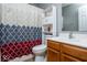 Cozy bathroom featuring updated vanity, matching toilet, and shower with patterned curtain at 2421 Grand Fir Dr, Greenwood, IN 46143