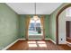 Elegant dining room features hardwood floors, soft green walls, brick archway, and a large window at 250 W Tansey Crossing, Westfield, IN 46074