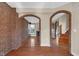 An open-concept living space is defined by brick arches and hardwood floors at 250 W Tansey Crossing, Westfield, IN 46074