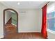 Bright living room with hardwood floors, brick archway, and large window with red curtains at 250 W Tansey Crossing, Westfield, IN 46074