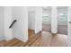 Hallway with wood-style flooring leading to a bedroom, showcasing open doorways and natural light at 2578 Filson St, Carmel, IN 46032
