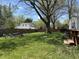 Large backyard with a wooden picnic table and chairs surrounded by a grass yard enclosed with a tall wooden fence for privacy at 2843 Canterbury Ln, Indianapolis, IN 46220