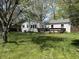 Spacious backyard with a well-maintained lawn, deck, and mature trees providing shade and privacy at 2843 Canterbury Ln, Indianapolis, IN 46220