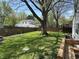Lush backyard featuring a large tree, garden, and a wooden fence, offering privacy and space at 2843 Canterbury Ln, Indianapolis, IN 46220