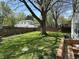 Grassy backyard surrounded by a wood privacy fence and shade trees creates an outdoor living space at 2843 Canterbury Ln, Indianapolis, IN 46220