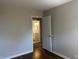 Bedroom with hardwood floors, neutral paint, and an open doorway into a bright bathroom at 2843 Canterbury Ln, Indianapolis, IN 46220