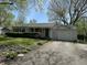 Well-maintained home featuring a covered porch, an attached garage, and lovely landscaping in the front yard at 2843 Canterbury Ln, Indianapolis, IN 46220