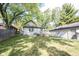 A well-maintained backyard with lush green grass, a deck, and mature trees providing shade at 2909 Huntsville Rd, Pendleton, IN 46064