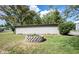 A stone fire pit surrounded by green grass and a tan wooden fence create a cozy backyard ambiance at 2909 Huntsville Rd, Pendleton, IN 46064