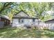 A well-maintained backyard with lush green grass, a wooden deck, and mature trees providing shade at 2909 Huntsville Rd, Pendleton, IN 46064