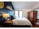 Comfortable bedroom with a blue accent wall, shelving, and abundant natural light at 2909 Huntsville Rd, Pendleton, IN 46064