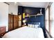 Stylish bedroom featuring a navy accent wall, floating shelf and wood closet doors at 2909 Huntsville Rd, Pendleton, IN 46064