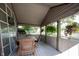 Inviting covered porch featuring wood-look flooring, a dining set, and hanging plants at 2909 Huntsville Rd, Pendleton, IN 46064